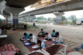 Sau khi Ấn Độ đóng cửa toàn bộ trường học từ tháng 3 vừa qua, nhiều học sinh không có điều kiện tiếp cận internet đã tham gia lớp học ngoài trời. (Ảnh: Reuters)