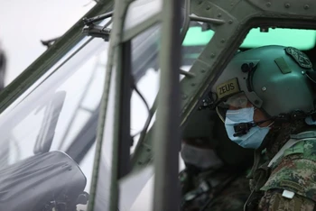 Phi công của quân đội quốc gia Colombia đeo khẩu trang khi điều khiển trực thăng trong thời điểm dịch Covid-19 bùng phát tại Bogota, ngày 7-4. (Ảnh: Reuters)