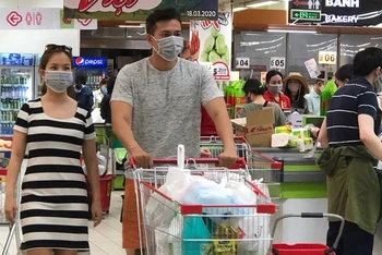 Người dân đeo khẩu trang khi đi mua sắm tại siêu thị vào tháng 3-2020. (Ảnh: T. Xuân)