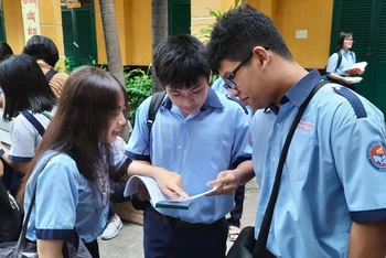 Các thí sinh tại điểm thi Trường THPT Trưng Vương, quận 1, TP Hồ Chí tranh thủ ôn bài trước khi bước vào phòng thi. 