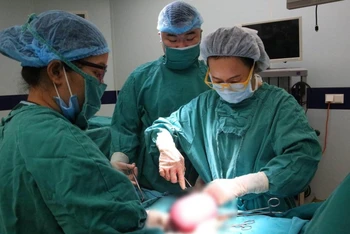 Các bác sĩ phẫu thuật, cắt khối u cho nữ bệnh nhân. 