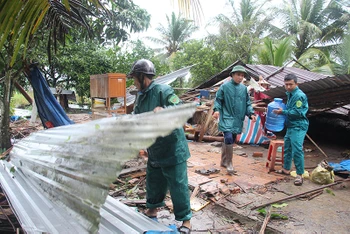 Lực lượng tại chỗ đang giúp bà Phan Thị Nhiên thu dọn nhà bị sập.