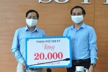 Phó Chủ tịch UBND TP Tam Kỳ Nguyễn Hồng Lai (bên phải) trao biểu trưng 20 nghìn khẩu trang cho Sở Y tế. 