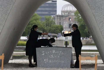Thị trưởng Matsui Kazumi chuẩn bị đặt danh sách nạn nhân của vụ ném bom vào bên trong bia tưởng niệm. (Ảnh: Kyodo News)