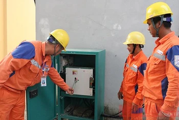 Công nhân kĩ thuật Công ty Điện lực Điện Biên kiểm tra bản an toàn hệ thống điện.