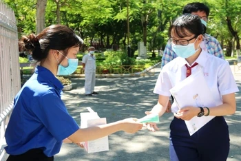 Thanh niên tình nguyện phát khẩu trang cho thí sinh ngay tại cổng vào các điểm thi.