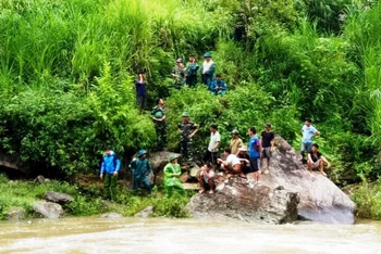 Lực lượng cứu hộ tìm kiếm nạn nhân bị mất tích do lũ cuốn trôi, khi đi qua suối Tả Củ Tỷ (Bắc Hà- Lào Cai).