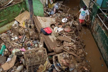 Người dân tại Jakarta, Indonesia dọn dẹp sau khi xảy ra ngập úng ngày 3-1. (Ảnh: Antara)