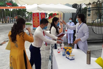 Công chức, viên chức ở Thanh Hóa rửa tay, được kiểm tra thân nhiệt trước khi tham dự sự kiện đông người.
