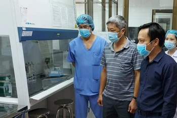 Thứ trưởng Nguyễn Trường Sơn (giữa) và TS Hoàng Quốc Cường (phải) kiểm tra quy trình vận hành của phòng xét nghiệm mà Viện Pasteur TPHCM lắp đặt tại Bệnh viện C Đà Nẵng.