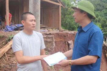 Đồng chí Lê Khánh Hòa, Bí thư Huyện ủy Nậm Pồ, trao hỗ trợ cho gia đình bị lũ cuốn trôi nhà.