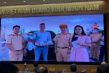Phòng CSGT Hà Nội trao biển số ô-tô cho anh Nguyễn Việt Hưng - công dân đầu tiên thực hiện thành công dịch vụ công thứ 1.000 trên Cổng Dịch vụ công quốc gia. Ảnh: Quang Hiếu