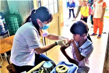 Cán bộ y tế tỉnh Đắk Lắk về tận vùng sâu tiêm vắc-xin phòng bệnh bạch hầu cho nhân dân. 