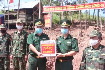 Đại tá Lê Văn Phương (bên phải) tặng quà cho chiến sĩ làm nhiệm vụ tại chốt phòng, chống Covid-19 thuộc Đồn Biên phòng cửa khẩu quốc tế La Lay.