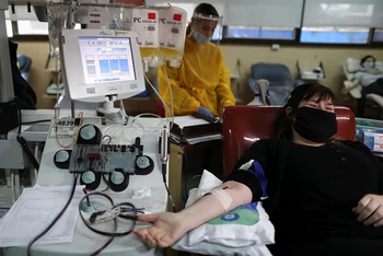 Một nữ bệnh nhân Covid-19 đã hoàn toàn hồi phục đang hiến huyết tương tại bệnh viện. Ảnh: Reuters