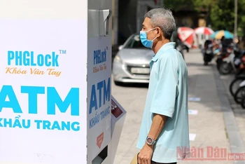 Người dân Hà Nội nhận khẩu trang y tế miễn phí từ "cây ATM khẩu trang".