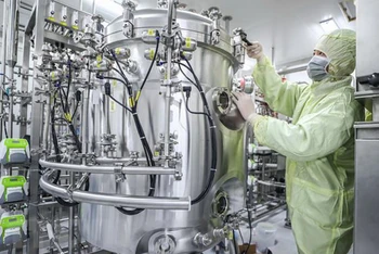 Nhân viên Tập đoàn dược quốc gia Trung Quốc (Sinopharm) điều chỉnh thiết bị sản xuất vắcxin tại nhà máy của Tập đoàn ở Bắc Kinh (Ảnh: THX/TTXVN)