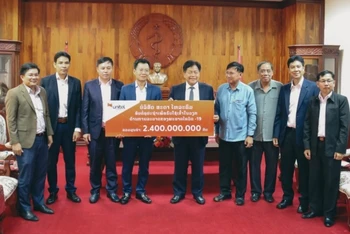 Bộ trưởng Y tế Lào Bounkong Sihavong (giữa) nhận tượng trưng 2,4 tỷ kíp Lào của Tổng Giám đốc Công ty Star Telecom Lưu Mạnh Hà.
