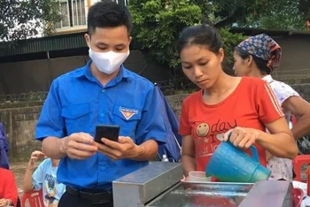 Đề nghị người dân và các hộ gia đình hãy cùng hợp tác và ủng hộ khi các tổ chức, đoàn thể hỗ trợ cài đặt ứng dụng Bluezone. Trong ảnh là tình nguyện viên hướng dẫn cài đặt Bluezone cho người bán nước mía ở Lào Cai.