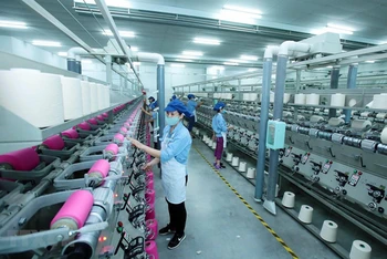 Công nhân sản xuất sản phẩm dệt nhuộm tại Công ty TNHH Dệt nhuộm Jasan Việt Nam. Ảnh: Phạm Kiên/TTXVN