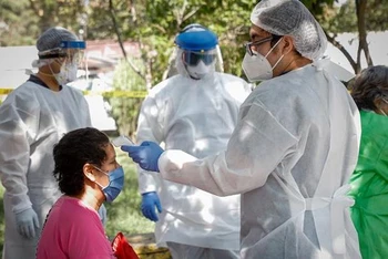  Nhân viên y tế lấy mẫu xét nghiệm Covid-19 tại Mexico City, Mexico. (Ảnh: THX/TTXVN)
