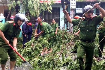 Công an tỉnh Thừa Thiên Huế cùng các đơn vị chức năng dọn dẹp cây xanh ngã đổ do bão số 5 gây ra trên địa bàn. Ảnh: CÔNG HẬU