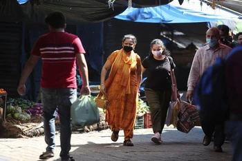 Người dân đeo khẩu trang khi đi trong khu chợ tại Jammu, Ấn Độ, ngày 23-9. (Ảnh: AP)