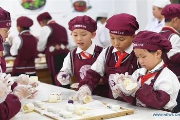 Học sinh của Trường tiểu học Huaguoyuan 3, tại tỉnh Quý Châu, tây nam Trung Quốc hào hứng làm bánh Trung thu. (Ảnh: Tân Hoa xã)