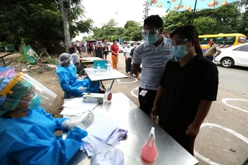 Nhân viên y tế thu thập thông tin về tình trạng sức khỏe của người dân trong chiến dịch kiểm tra sức khỏe và truy vết tiếp xúc tại Yangon, Myanmar, ngày 8-9. (Ảnh: Tân Hoa xã)