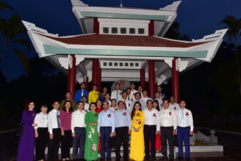Các đồng chí đại biểu chụp ảnh lưu niệm tại Nhà bia kỷ niệm nơi làm việc của Ban Tổ chức Trung ương, tại thôn Tân Lập, xã Tân Trào, huyện Sơn Dương, tỉnh Tuyên Quang.