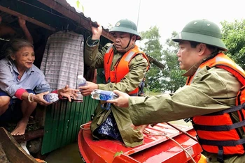 Bí thư Tỉnh ủy Quảng Bình Vũ Đại Thắng (phải) trao nước uống cho người dân “rốn lũ” Tân Hóa.