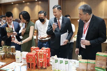 Các đại biểu tham quan gian hàng trưng bày sản phẩm của doanh nghiệp trong nước tại hội nghị.