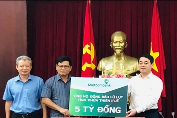 Thay mặt Vietcombank, đồng chí Nghiêm Xuân Thành, Bí thư Đảng ủy, Chủ tịch HĐQT (ngoài cùng bên phải) trao số tiền 5 tỷ đồng ủng hộ đồng bào tỉnh Thừa Thiên Huế.