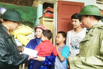 Thứ trưởng Quốc phòng Nguyễn Tân Cương (bên trái) cùng Chủ tịch UBND tỉnh Quảng Trị Võ Văn Hưng thăm, tặng quà cho hộ dân xã Triệu Thành, huyện Triệu Phong.