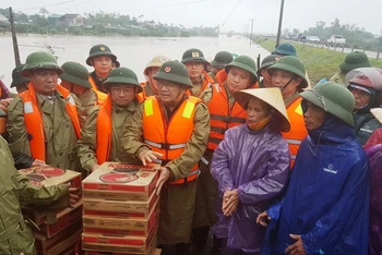 Phó Thủ tướng Trịnh Đình Dũng động viên và trao quà cho người dân vùng lũ.