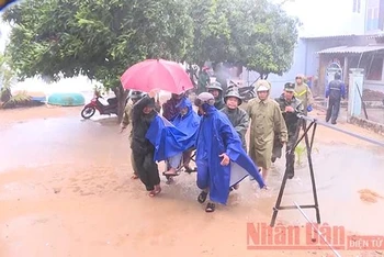Các lực lượng chức năng giúp người già ở xã Phổ Thạnh, huyện Đức Phổ, Quảng Ngãi sơ tán tránh bão số 6 năm 2019. Ảnh: HIỀN CỪ.