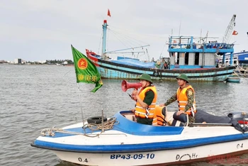 Bộ đội biên phòng Quảng Nam dùng loa cảnh báo tàu thuyền tránh bão số 9. 