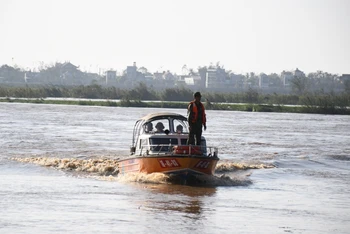 Lực lượng chức năng sử dụng cano đưa công nhân mắc kẹt giữa sông Trà Khúc vào bờ.