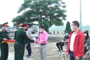 Trao giấy chứng nhận hoàn thành cách ly cho các công dân trở về từ Liên bang Nga tại cơ sở cách ly tập trung tỉnh Nam Định (thị trấn Gôi, huyện Vụ Bản).
