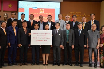 Đại diện Hội người Thái gốc Việt toàn Thái Lan trao tượng trưng số tiền quyên góp ủng hộ đồng bào miền trung.
