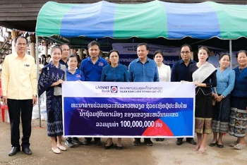 Đại diện LaoVietBank trao ủng hộ người dân lũ lụt tại tỉnh Savannakhet, miền trung Lào với sự chứng kiến của Chủ tịch Quốc hội Lào Pany Yathotou.