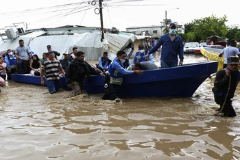 Cảnh sát sơ tán người dân sống trong khu vực bị ngập úng tại Honduras, ngày 6-11. (Ảnh: AP)