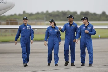 Bốn phi hành gia đi bộ sau khi đến Trung tâm Vũ trụ Kennedy. Họ sẽ được phóng trên tàu vũ trụ Crew Dragon của SpaceX chuyến chính thức đầu tiên tới Trạm vũ trụ quốc tế dự kiến vào ngày 14-11. Ảnh: AP.