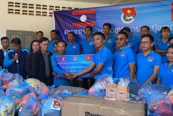 Ông Giang Công Huân (phải) tại buổi lễ trao ủng hộ các gia đình khó khăn tại xã Namka, huyện Phaxay, tỉnh Xiengkhuang. (Ảnh: Hội Thanh niên Việt Nam tỉnh Xiengkhuang)