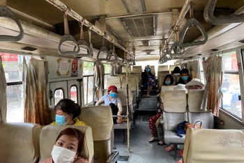 Hành khách đi xe buýt thực hiện đeo khẩu trang để bảo đảm an toàn, phòng chống dịch Covid-19.