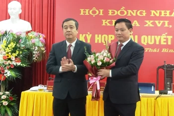 Bí thư Tỉnh ủy Thái Bình Ngô Đông Hải (bên trái) tặng hoa chúc mừng ông Nguyễn Khắc Thận giữ chức Chủ tịch UBND tỉnh.