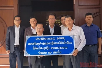 Đồng chí Somchit Panyasack (trái) trao 80 triệu kíp Lào ủng hộ nhân dân miền trung Việt Nam bị ảnh hưởng bởi bão lũ.