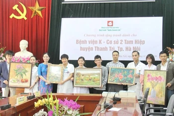 Họa sĩ Nguyễn Thị Kim Đức (thứ ba từ trái sang) trao tặng bộ tranh cho Bệnh viện K cơ sở 2. (Ảnh: Nguyễn Hoàng)
