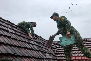 Bộ đội biên phòng Quảng Bình giúp người dân huyện Bố Trạch lợp lại nhà.
