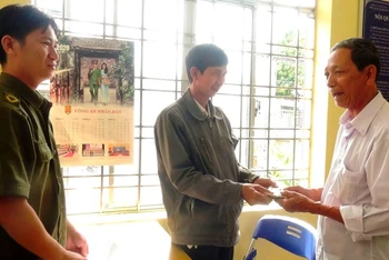Ông Nguyễn Văn Thái (đứng giữa) trao trả tài sản cho ông Sơn dưới sự chứng kiến của Công an xã. 
